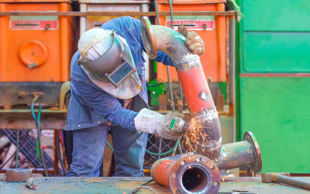 welder using grinder machine to polishing steel pipe